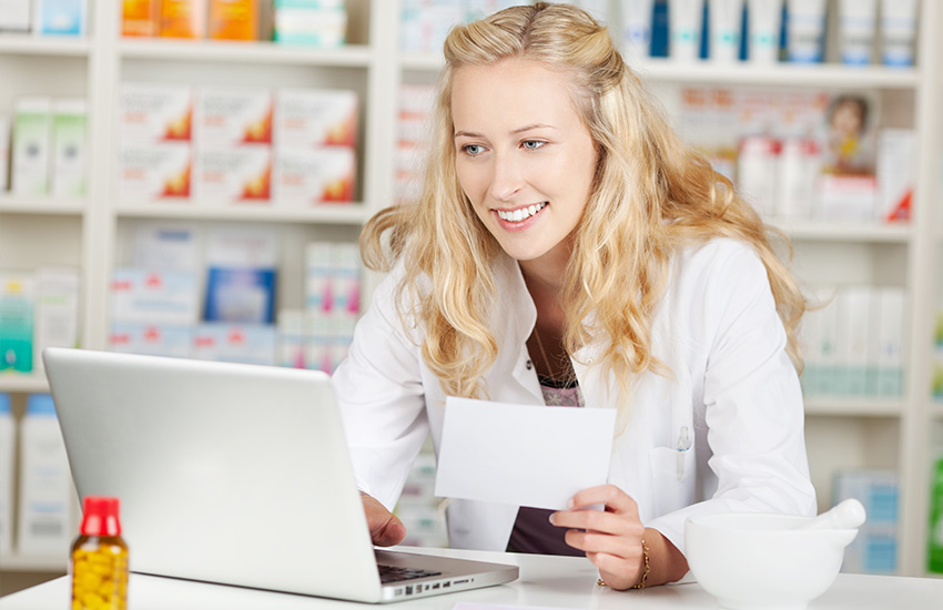 Una farmac&eacute;utica consulta la informaci&oacute;n de un documento en un ordenador port&aacute;til